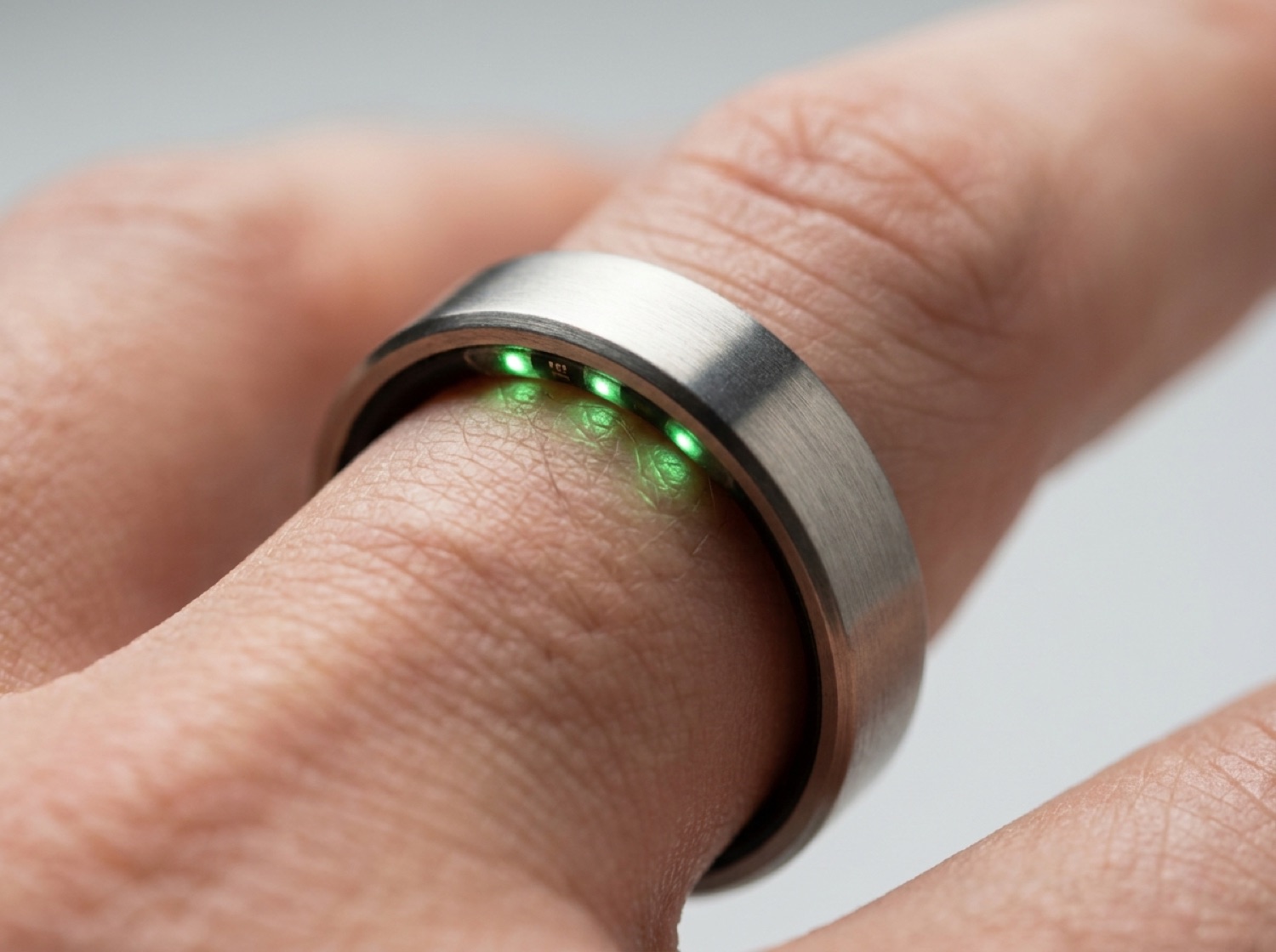 Nahaufnahme eines Fitness-Rings mit LED-Sensoren an der Innenseite, der Blutgefäße am Finger optisch erfasst