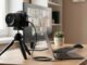 Systemkamera auf einem Stativ, die am Schreibtisch als Webcam für eine Videokonferenz dient